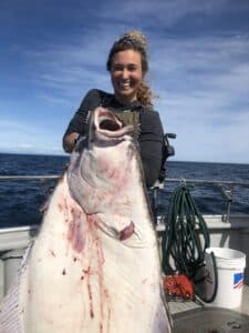 woman-holding-large-halibut-1-scaled Woman holding a halibut after a fishing trip in Resurrection Bay
